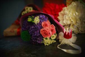 un' mazzo per il compleanno di un' poco ragazza di rosa Rose, un' blu ortensia e un' bianca eustoma e gerbera bugie su il tavolo. decorazione nel il modulo di un' rosa corona. foto