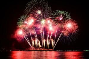 incredibile bellissimo spettacolo pirotecnico colorato nella notte di celebrazione, che mostra sulla spiaggia del mare con multi colore di riflessione sull'acqua foto