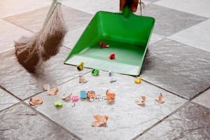 spazzare con una scopa e una paletta i ritagli di piastrelle di carta. foto