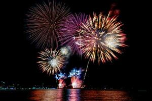 incredibile bellissimo spettacolo pirotecnico colorato nella notte di celebrazione, che mostra sulla spiaggia del mare con multi colore di riflessione sull'acqua foto