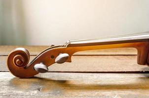 il violino sul tavolo, primo piano del violino sul pavimento di legno foto