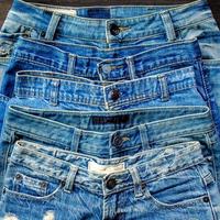 i jeans blu e i jeans mancano di consistenza sul tavolo, i jeans si sovrappongono. foto