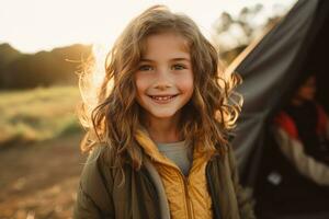 ritratto di carino poco ragazza a telecamera mentre in piedi vicino campeggio tenda a tramonto ai generato foto