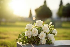 bianca fiori nel davanti di un' pietra sepolcrale a un' cimitero con tramonto.funerale concetto ai generato foto