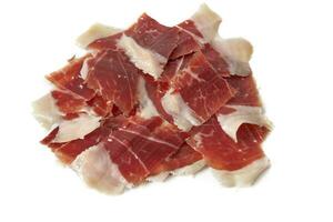 affettato iberico serrano prosciutto isolato su bianca sfondo. iberico serrano prosciutto è un' spagnolo delicatezza,famoso per suo fumoso gusto e tenero, salato struttura, il ricchezza di il iberico culinario tradizione foto