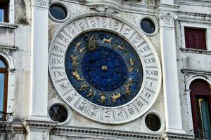 un' grande orologio con zodiaco segni su il lato di un' edificio foto
