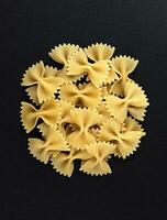 crudo farfalle pasta isolato su nero sfondo, superiore Visualizza foto