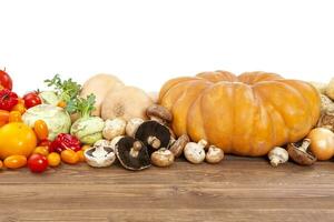 autunno verdure raccogliere su di legno tavolo, bianca sfondo. zucca, zucchine, patate, cipolle e altro verdure. foto