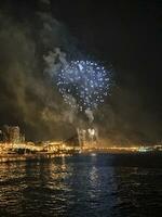 colorato fuochi d'artificio nel il notte cielo su il lungomare di alicante Spagna foto