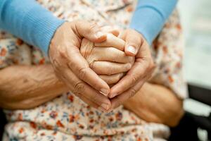 badante Tenere mani asiatico anziano donna paziente con amore, cura, incoraggiare e empatia a assistenza infermieristica Ospedale, salutare forte medico concetto. foto