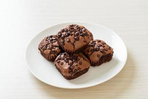 Brownies al cioccolato fondente ricoperti da gocce di cioccolato foto