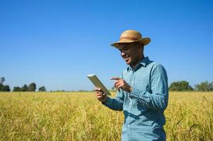un agricoltore che tiene un tablet per controllare i risultati finanziari