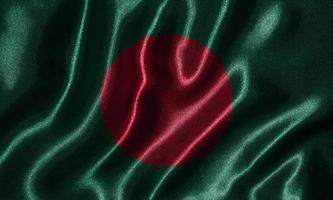 carta da parati della bandiera del Bangladesh e sventolando la bandiera del tessuto. foto