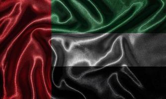 carta da parati della bandiera degli emirati arabi e sventolando la bandiera del tessuto. foto