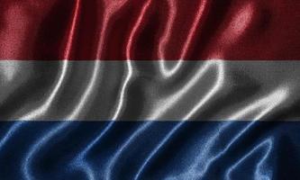 carta da parati della bandiera dei Paesi Bassi e sventolando la bandiera del tessuto. foto