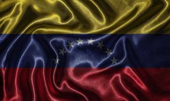 carta da parati della bandiera del venezuela e sventolando la bandiera del tessuto. foto