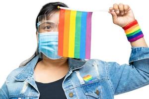 signora asiatica che tiene bandiera color arcobaleno, simbolo di lgbt foto