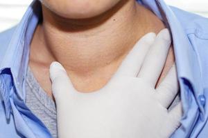 il paziente asiatico ha un ingrossamento anomalo della tiroide alla gola foto