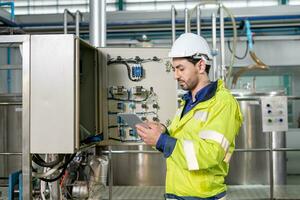 ingegneri o utilità personale indossare sicurezza casco fix il macchine nel il produzione linea. utilità ispettore dai un'occhiata macchina e test il sistema per incontrare il standard. macchina, preventivo Manutenzione foto