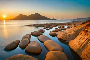 il sole imposta al di sopra di un' spiaggia con rocce e acqua. ai-generato foto