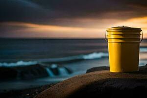 un' giallo secchio si siede su un' roccia vicino il oceano. ai-generato foto