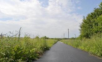 bella strada asfaltata vuota in campagna su sfondo colorato foto