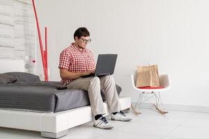 giovane che fa shopping su internet con il laptop foto