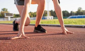 giovane donna pronta a correre alla pista dello stadio foto