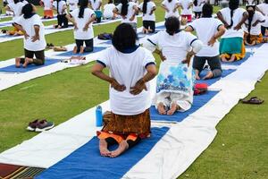 nuovo delhi, India, giugno 21, 2023 - gruppo yoga esercizio sessione per persone a yamuna gli sport complesso nel delhi su internazionale yoga giorno, grande gruppo di adulti frequentando yoga classe nel cricket stadio foto