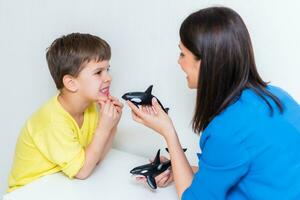 carino donna discorso terapista insegna bambino per pronunciare parole suoni e lettere correttamente nel ufficio foto