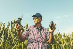 moderno tecnologico contadino come lui prepara per volare il fuco al di sopra di il suo coltivato i campi foto