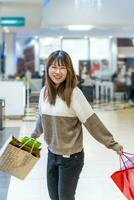 bella contento giovane Cinese donna con colorato shopping borse foto