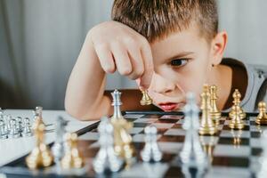 bambino giochi scacchi nel il suo camera a casa foto