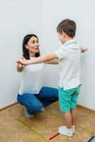 attraente donna discorso terapista insegna bambino per pronunciare suoni e parole correttamente nel ufficio foto