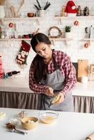 donna latina che versa il miele sull'impasto cucinando in cucina