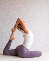 giovane donna attraente che pratica yoga, indossando abbigliamento sportivo foto
