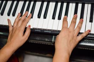 asiatico ragazzo giocando il sintetizzatore o pianoforte. carino poco ragazzo apprendimento Come per giocare pianoforte. del bambino mani su il tastiera interno. foto