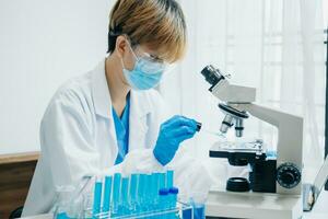 moderno medico ricerca laboratorio. femmina scienziato Lavorando con micro pipette analizzando biochimica campioni, Avanzate scienza chimico laboratorio foto