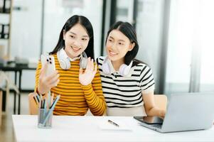 asiatico studenti siamo studiando il città universitaria parco. giovane persone siamo la spesa tempo insieme. lettura prenotare, Lavorando con computer portatile, tavoletta e comunicare mentre nel Università biblioteca foto