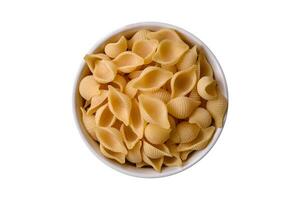 crudo italiano pasta conchiglie a partire dal duro Grano con la verdura, sale e spezie foto