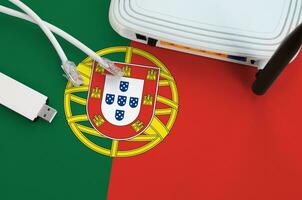 Portogallo bandiera raffigurato su tavolo con Internet rj45 cavo, senza fili USB Wi-Fi adattatore e router. Internet connessione concetto foto