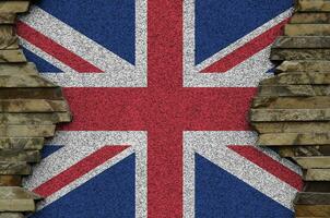 grande Gran Bretagna bandiera raffigurato nel dipingere colori su vecchio pietra parete avvicinamento. strutturato bandiera su roccia parete sfondo foto