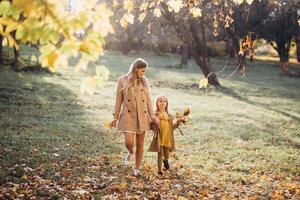 madre e figlia si divertono e camminano nel parco autunnale. foto