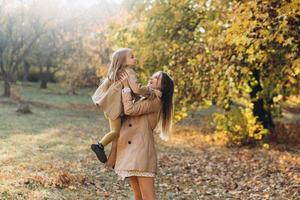 madre e figlia si divertono e camminano nel parco autunnale. foto