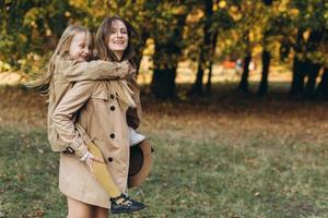 madre e figlia si divertono e camminano nel parco autunnale. foto