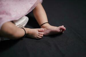 neonato del bambino piedi su il nero sfondo foto
