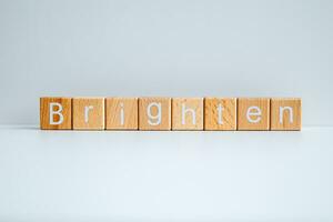 di legno blocchi modulo il testo Brighten contro un' bianca sfondo. foto