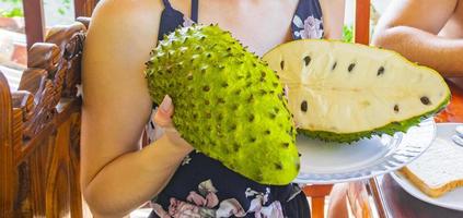 la donna tiene la frutta tropicale affettata del sauersack della soursop nello sri lanka. foto