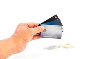mano umana che tiene un gruppo di carte di credito bancarie su sfondo bianco.