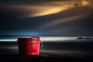un' rosso secchio si siede su il spiaggia a notte. ai-generato foto